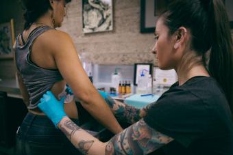 Tattoo artist applying tattoo transfer