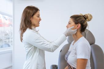 Female dermatologist performing a procedure on a patient 