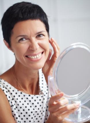 middle aged woman examining face