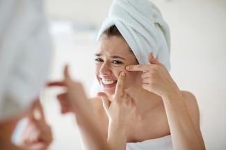 Woman trying to pop a hard pimple