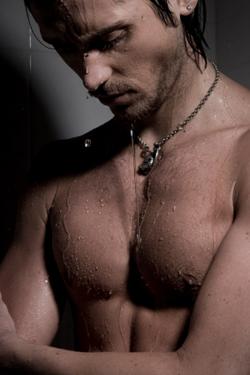 Muscular man taking a shower