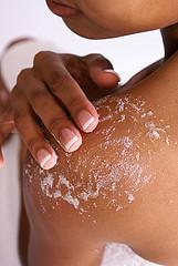 Woman exfoliating skin