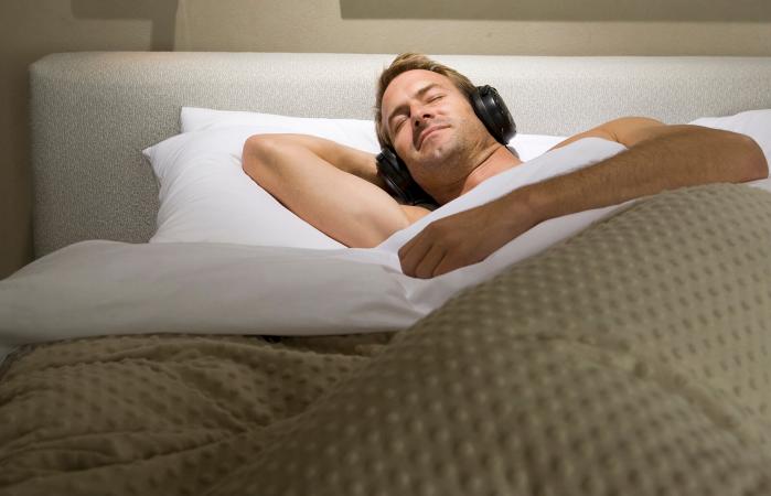 Man sleeping in bed with headphones