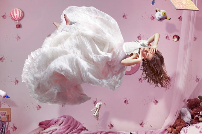 Young girl in long white dress dreaming of falling