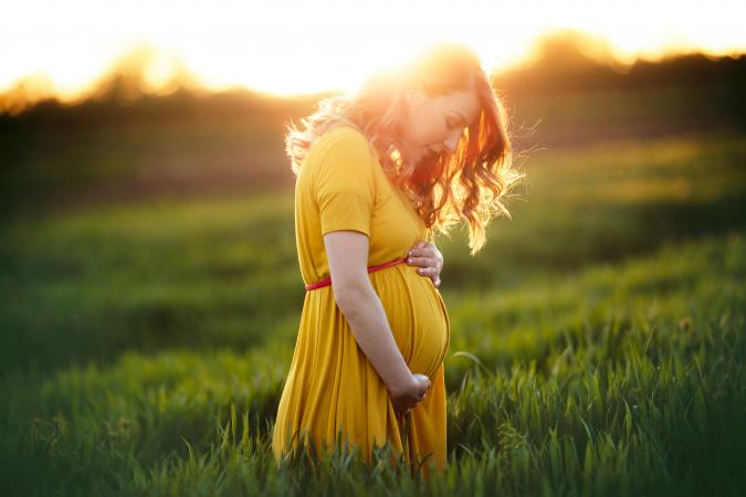 Pregnant woman relaxing in nature on a beautiful sunny day