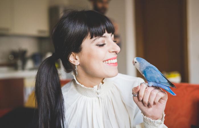woman smiling at pet bird