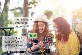 Two happy friends texting