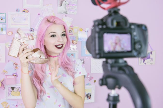 Pink vlogger holding fashion shoe