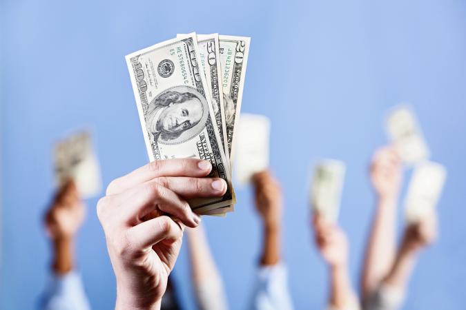 hands holding up money