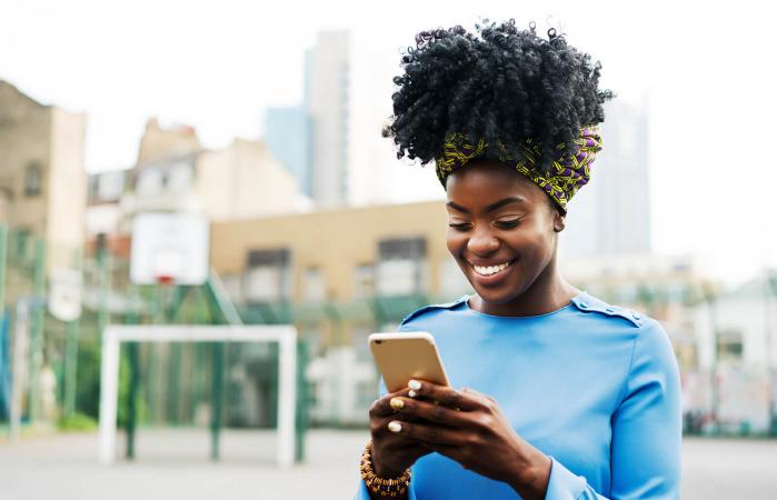 Woman using smart phone in city