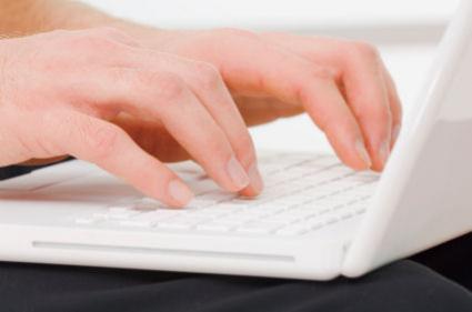 Person typing a blog script on a laptop