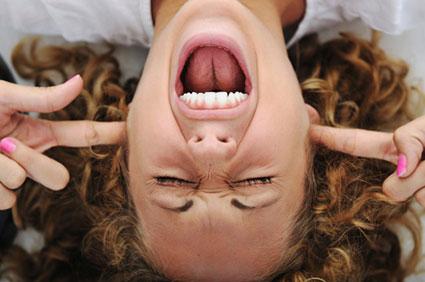 Stressed out woman shouting with fingers in ears