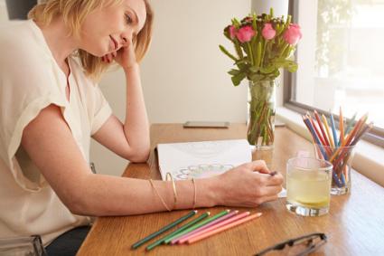 Woman relaxing at home with coloring book