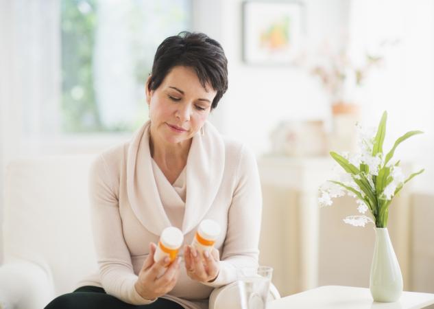 woman looking at pill bottles