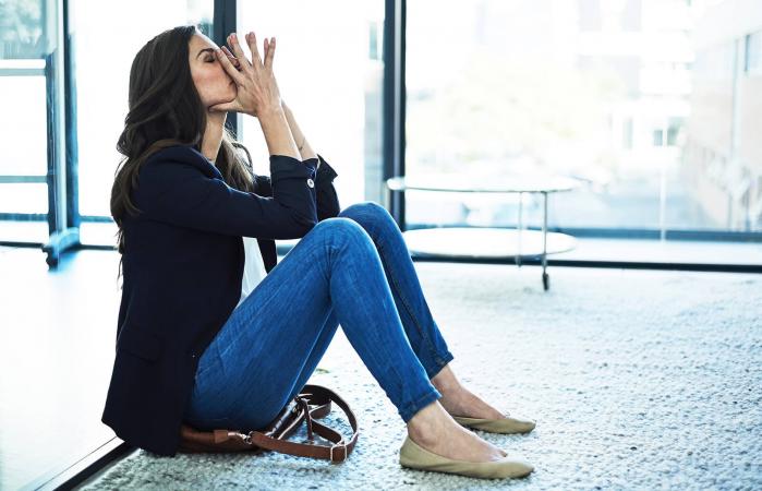 Stressed businesswoman sitting on the floor