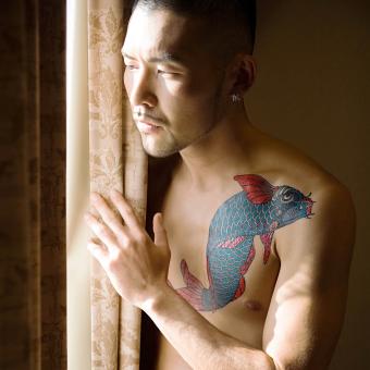 hombre con tatuaje azul koi
