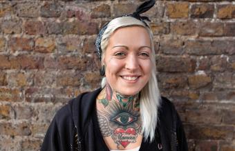Chica sonriente con tatuajes en el cuello