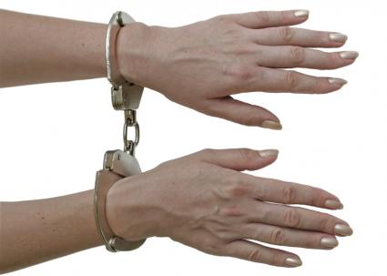 Women's hands in hand cuffs