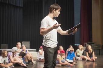 Students practicing lines on stage