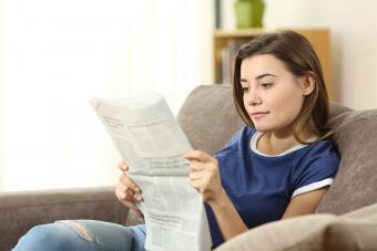 teen reading a newspaper