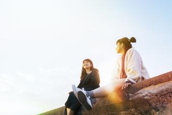 2 friends sitting on a wall