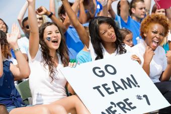 Excited high school sports fans cheering and holding sign