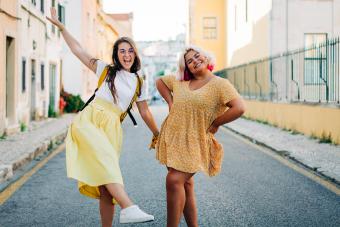 Friends having fun while standing on road in city