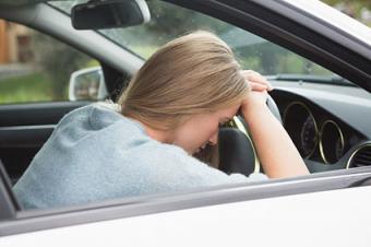 Woman asleep on steering wheel