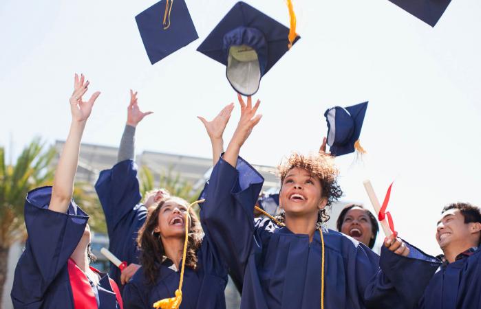 Graduates tossing caps into the air