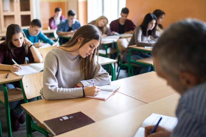 Teens writing in notebooks in class