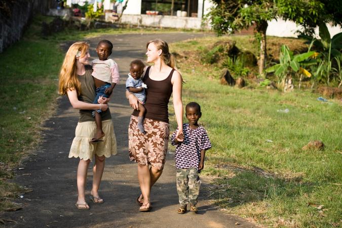 Two young missionaries with African children