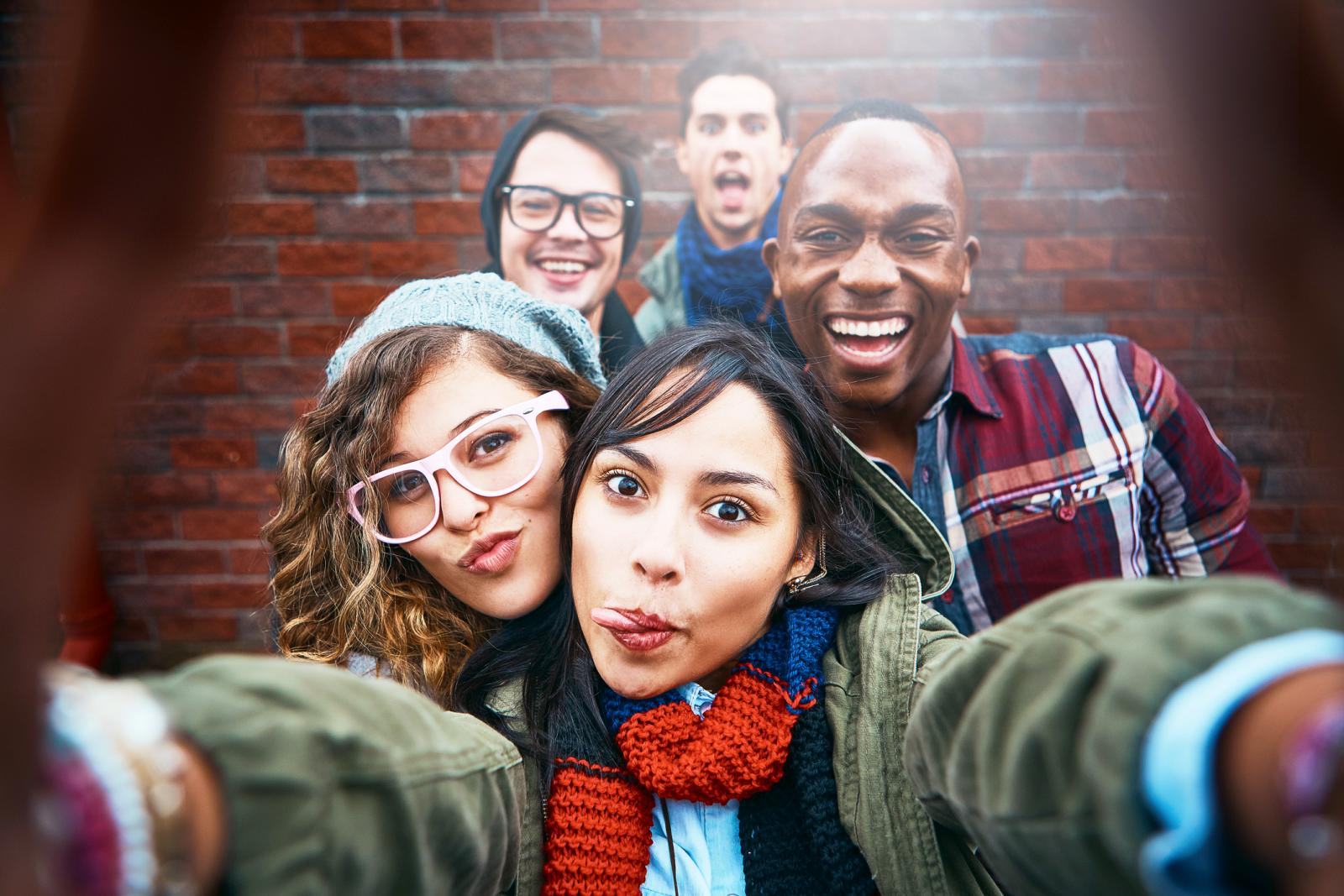 Group of happy friends take selfie outdoors