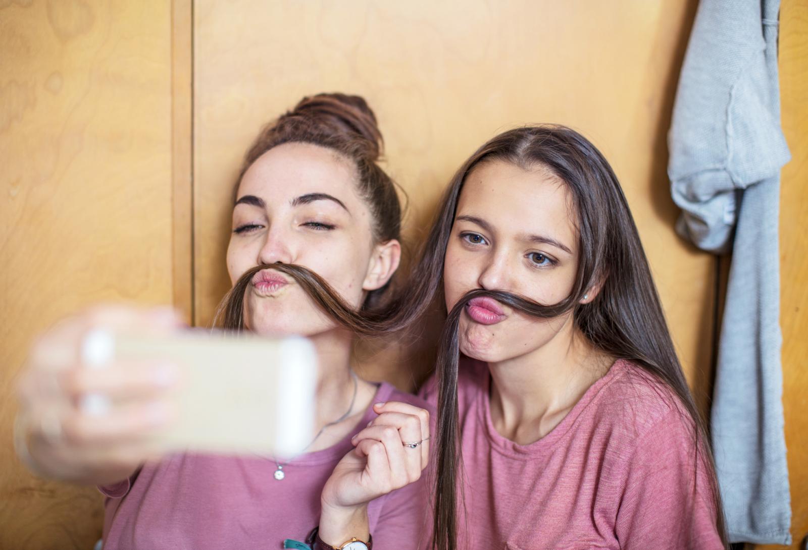 Playful happy teenage girls taking a selfie