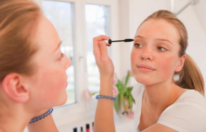 Teenage girl applying mascara