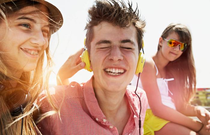 happy teenage friends with headphones outdoors