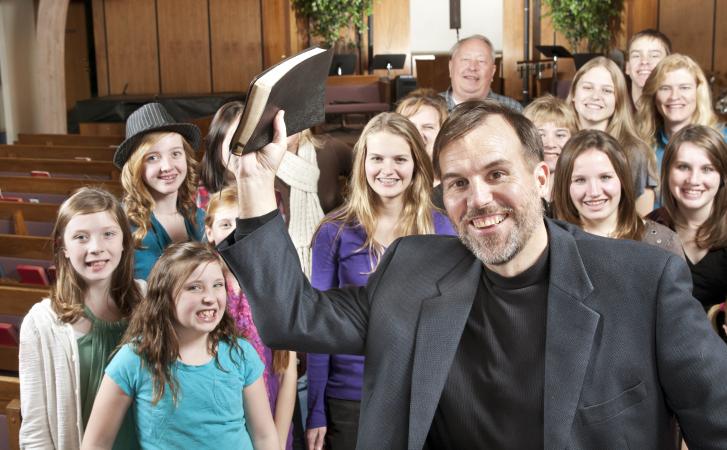 Pastor holding Bible with youth group