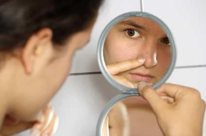 Girl pointing at pimple
