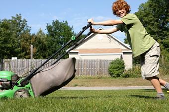 kid mowing grass