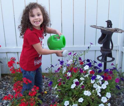 Child watering plants with Little Tikes Watering Can