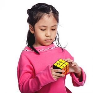 Little girl playing with a Rubik Cube