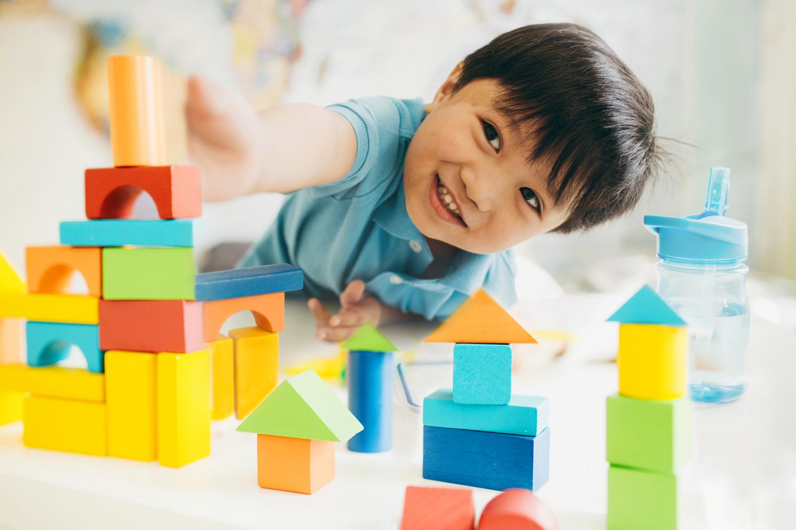 Kid playing with wooden blocks