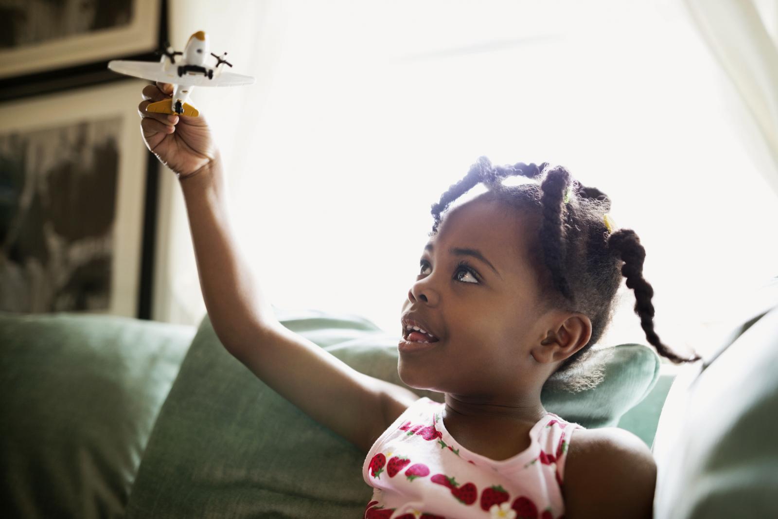 Girl flying toy airplane