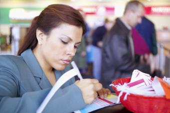 Woman at the airpot writing on a luggage tag
