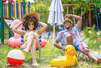 Couple sitting on lounge chairs in the back yard and having sunbath during their staycation