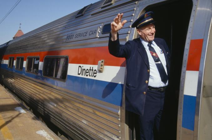Amtrak conductor waving from inside train