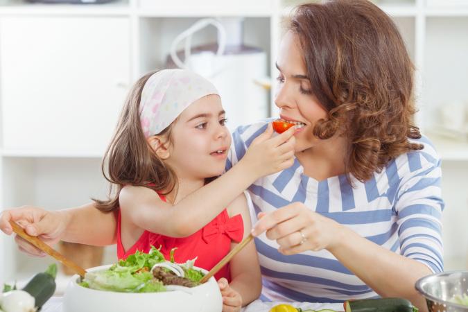 Kid and mom eating veggies together