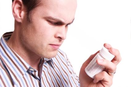 man studying vitamin bottle