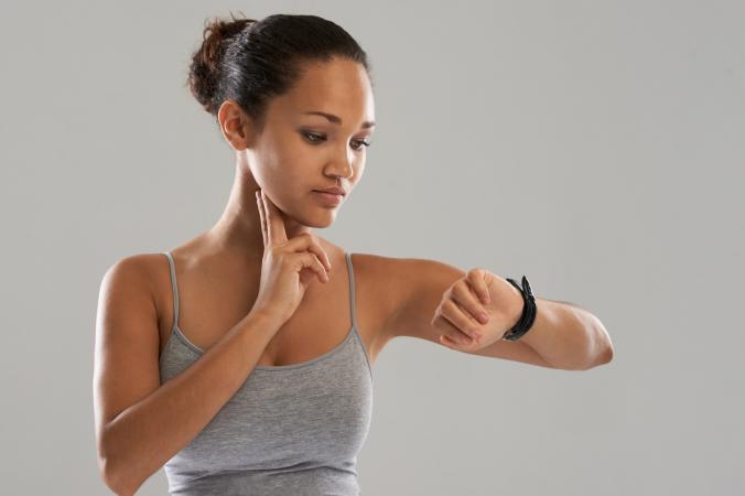 Woman in sportswear timing her heartbeat
