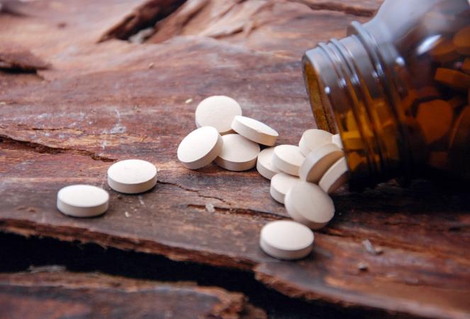 Vitamin pills and bottle on stone