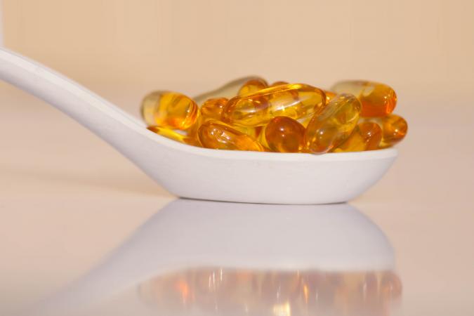 Vitamin D capsules in a spoon